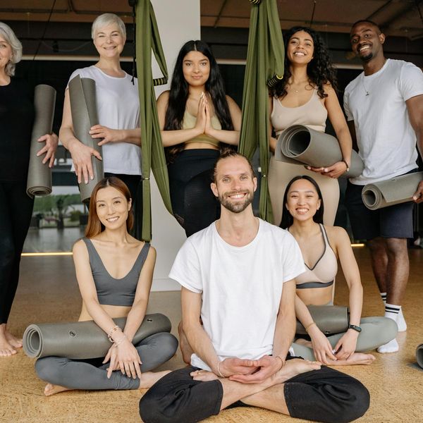 Group of diverse pregnant women smiling in a yoga class.